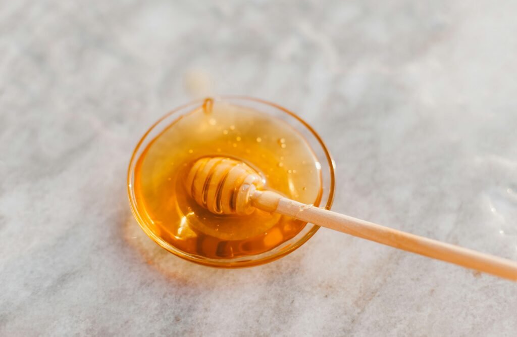honey in a glass bowl with a wooden honey dipper kashmiri natural honey 